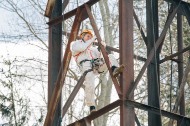 Endüstriyel dağcı üniforma ve kask yüksekliği açık havada üzerinde çalışıyor. Profesyonel çalışan su kulesi riskli onun işi. 