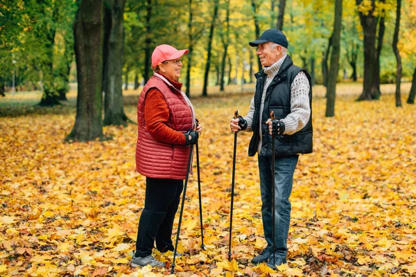 Pretty Senior Couple Standing Nordic Walking Poles Colorful Autumn Park — Stock Photo, Image