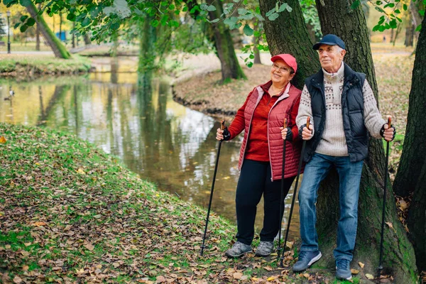 Pareja Bastante Mayor Pie Con Bastones Nórdicos Colorido Parque Otoño —  Fotos de Stock