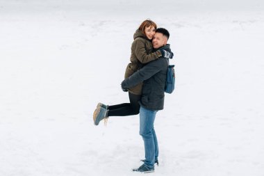 Genç güzel mutlu gülümseyen çift açık havada kış portresi. Noel ve kış tatili. Erkek ve kadın karlı Park