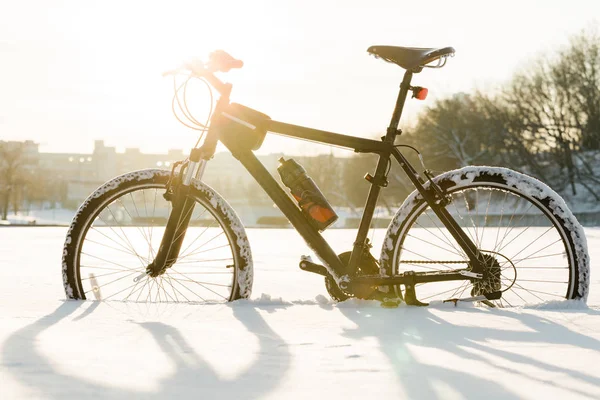 冬サイクリングします 市内中心部で雪の上の黒い自転車 いつでも年概念のスポーツ — ストック写真