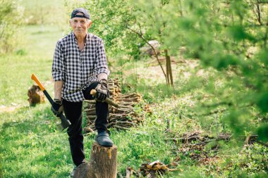 Odun kesmenin balta ile beyzbol şapkalı komuta sizde. Bahçede çalışan yaşlı arborist adam. Aktif Emeklilik yaşam tarzı kavramı.