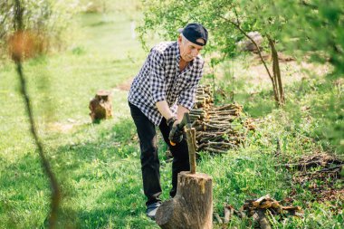 Odun kesmenin balta ile beyzbol şapkalı komuta sizde. Bahçede çalışan yaşlı arborist adam. Aktif Emeklilik yaşam tarzı kavramı.