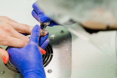 Parmak tırnak tedavisi, taşlama ve güzellik salonunda parlatma. Elektrikli tırnak dosyası ile Beautician