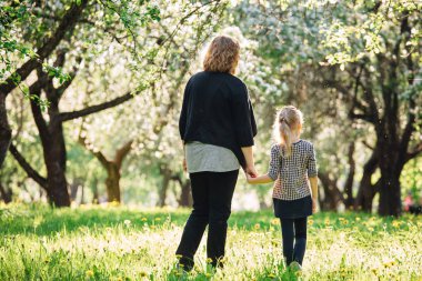 Anne ve kızı parkta eğleniyor. Aile hayatında mutluluk ve uyum. Aile açık yaşam tarzı ile güzellik doğa sahnesi. Kadın ve neşeli küçük kız