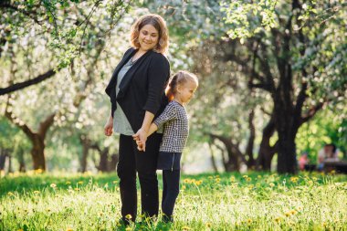 Anne ve kızı parkta eğleniyor. Aile hayatında mutluluk ve uyum. Aile açık yaşam tarzı ile güzellik doğa sahnesi. Kadın ve neşeli küçük kız