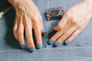 Kapatın. Terzi, terzi tebeşiri ile yaptığı elbisenin kalıbını belirliyor. Evde kumaş raptiyelerle çalışmak