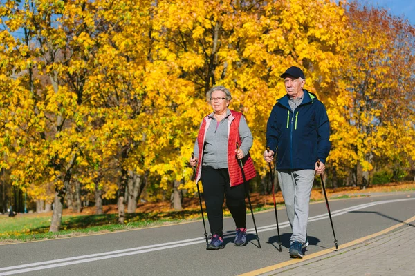 Hübsches Seniorenpaar Steht Mit Nordic Walking Stöcken Bunten Herbstpark Reife Stockbild