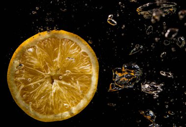 su siyah bir zemin üzerine portakal dilim su sıçramalarına