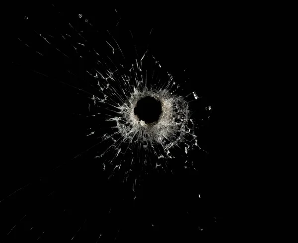 Glass with cracks and a hole from firearms