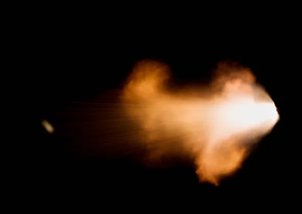 the flash from a shot from a firearm on a black background