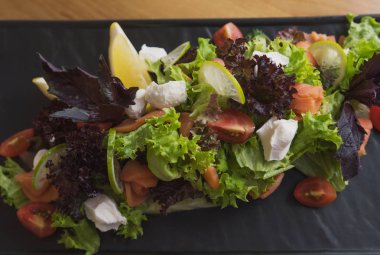 kafenin arka planında peynir, domates, narenciye, fesleğen ve marul ve soda ve buz ile kokteyl salatası