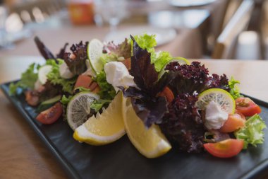 kafenin arka planında peynir, domates, narenciye, fesleğen ve marul ve soda ve buz ile kokteyl salatası