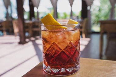 ahşap bir masa üzerinde bir yaz kafenin arka planda soda, viski ve portakal lezzet ile kokteyl