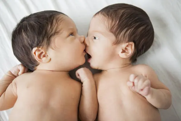 双胞胎可爱的小女孩在床上接吻 — 图库照片