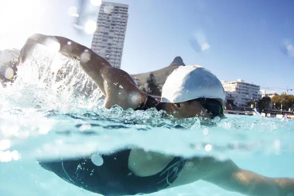日当たりの良いプールで泳ぐ男性水泳選手 — ストック写真