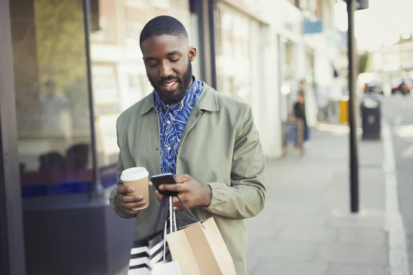 Hombre Joven Con Café Bolsas Compras Mensajes Texto Con Teléfono —  Fotos de Stock