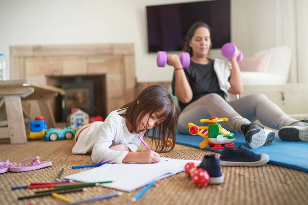 Daughter Coloring While Mother Exercises Living Room — Stock Photo, Image