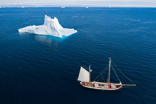 在阳光灿烂的蓝色大西洋格陵兰岛驶过宏伟冰山的船 — 图库照片