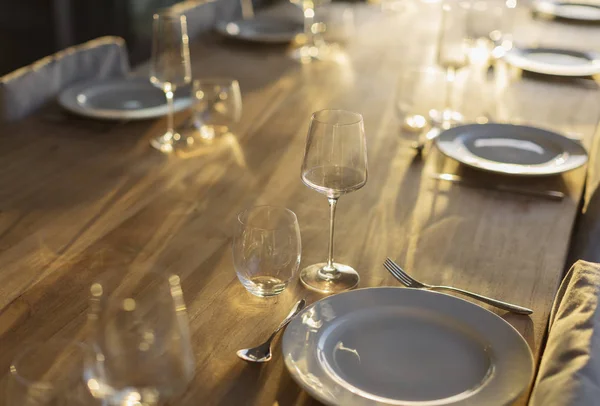 Réflexion ensoleillée sur placesettings sur table à manger en bois — Photo de stock