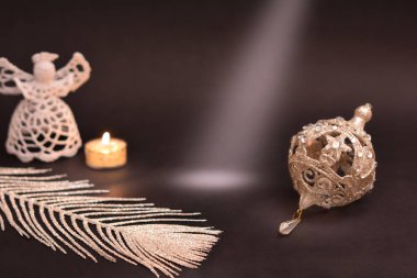 Noel süslemeleri siyah arka plan üzerine. Beyaz melek, mum, gümüş tüy ve Noel ağacı önemsiz şey, hafif ray üzerinde boş alan