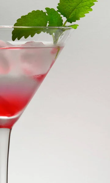 Um detalhe de vidro de bebida martini rosa com galho de hortelã — Fotografia de Stock