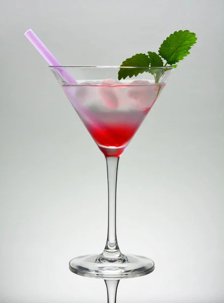 Um martini rosa beber vidro com galho de hortelã e palha — Fotografia de Stock