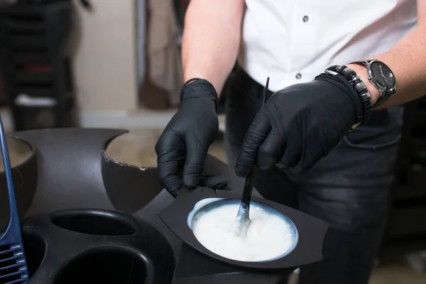 Estilista masculino em luvas preparando creme de cor para morrer hairin a — Fotografia de Stock