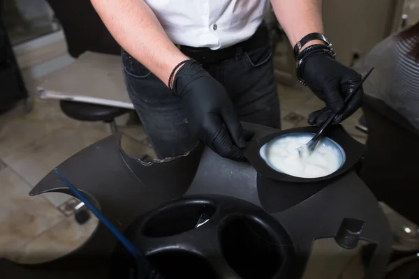 Estilista masculino em luvas preparando creme de cor para morrer hairin a — Fotografia de Stock