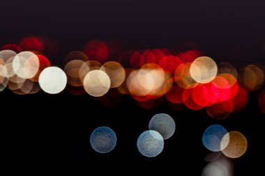 Bulanık bokeh, gece şehrinin kırmızı yuvarlak daireleri. Hareket U