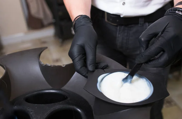 Estilista masculino em luvas preparando creme de cor para morrer hairin a — Fotografia de Stock