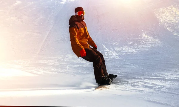 Snowboarder on snowboard  piste running downhill in beautiful Al