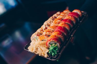 Büyük bir Suşi Rolls-Ilık Ebi Sake Unagi Baharı. Geleneksel restoranda bir tabakta Japon çiğ balığından bir sürü Philadelphia dürümü var. Japon yemek menüsü servisi