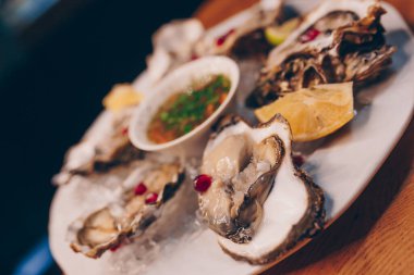 Aç İstiridye MisselsFines de Claire 'i limon ve bitki soslu bakır kasede tutan garson. Üst görünüm.