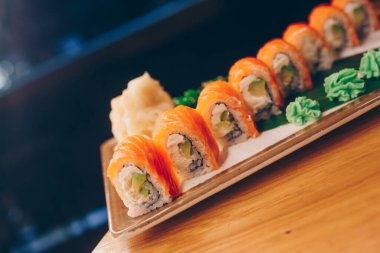 Büyük bir Suşi Rolls-Ilık Ebi Sake Unagi Baharı. Geleneksel restoranda bir tabakta Japon çiğ balığından bir sürü Philadelphia dürümü var. Japon yemek menüsü servisi