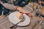 Frau sexy Hände servieren Erdbeerstück Käsekuchen mit Karamell in der Nähe eines Glases Champagner, Marmelade und Napoleon in einem Restaurant