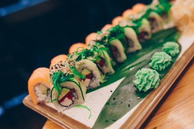 Büyük bir Suşi Rolls-Ilık Ebi Sake Unagi Baharı. Geleneksel restoranda bir tabakta Japon çiğ balığından bir sürü Philadelphia dürümü var. Japon yemek menüsü servisi