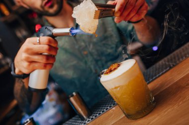 Barmen, barın tezgahına süzgeç gibi beyaz kokteyl döker. Profesyonel bakış açısı. Moda tarzı alkollü içecek. Gece kulübünde tasarımcılar ve konsept servisi barmeni.