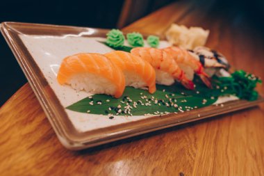 Büyük bir Suşi Rolls-Ilık Ebi Sake Unagi Baharı. Geleneksel restoranda bir tabakta Japon çiğ balığından bir sürü Philadelphia dürümü var. Japon yemek menüsü servisi