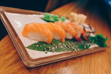 Büyük bir Suşi Rolls-Ilık Ebi Sake Unagi Baharı. Geleneksel restoranda bir tabakta Japon çiğ balığından bir sürü Philadelphia dürümü var. Japon yemek menüsü servisi