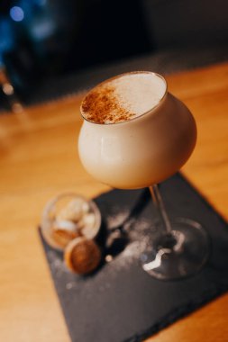 Buzlu, modern Cocktail gurme beyaz, tatlı karamel süslemeli, yazar içeceği tezgahta. Üst Manzara 'ya yakın çekim. Uzay tasarım barmenlerini ve lüks gece kulüplerini kopyala 