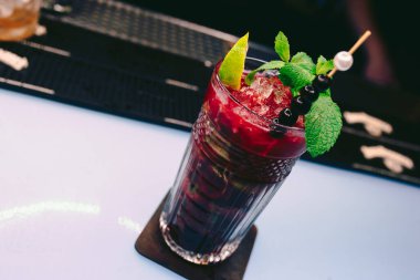 Taze çilek suyu, buz gibi soğuk, siyah üzümlü kokteyl, tatlı süslemeli, yazar içkisi tezgahta. Üst Manzara 'ya yakın çekim. Uzay tasarım barmenlerini ve lüks gece kulüplerini kopyala 