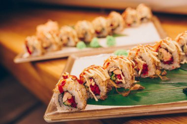 Büyük bir Suşi Rolls-Ilık Ebi Sake Unagi Baharı. Lüks geleneksel restoranda, Japon çiğ balığından yapılan çeşitli Philadelphia dürümleri. Japon yemek menüsü servisi