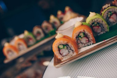 Büyük bir Suşi Rolls-Ilık Ebi Sake Unagi Baharı. Lüks geleneksel restoranda, Japon çiğ balığından yapılan çeşitli Philadelphia dürümleri. Japon yemek menüsü servisi