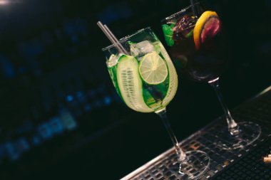 Taze Sağlıklı Meyve Suyu, buz gibi soğuk, meyve süsleme dilimli modern Kokteyl, tezgahta Yazar İçeceği. Üst Manzara 'ya yakın çekim. Uzay tasarım barmenlerini ve lüks gece kulüplerini kopyala 