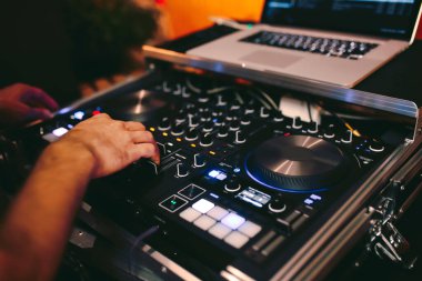 Dj 'in kırmızı parti dj ses donanımını kontrol ettiği genel çekim. Turntable top view gece kulübü ve not defterinde yüksek kaliteli karıştırma disk jokeyi. Gece kulübünde sahnede Pro ses ekipmanı.