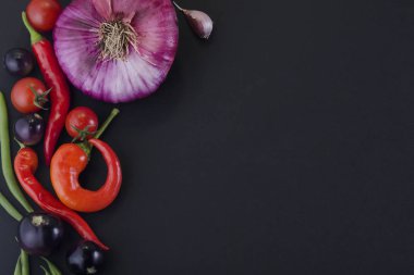 siyah arka planda soğan, sıcak biber ve sebze