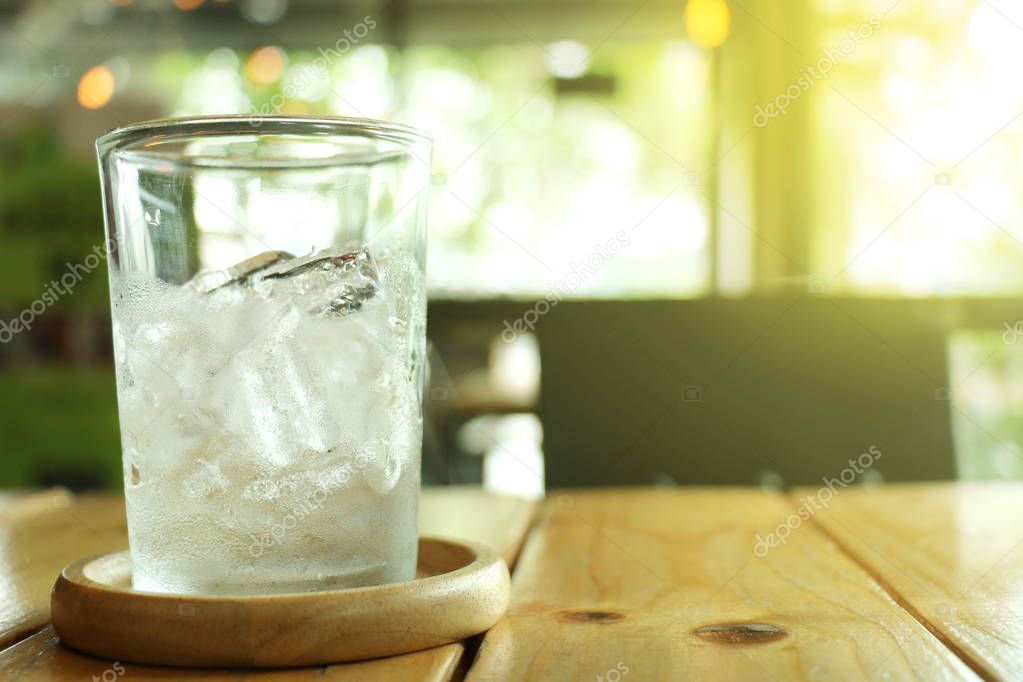 Ice in a glass placed on wooden coaster