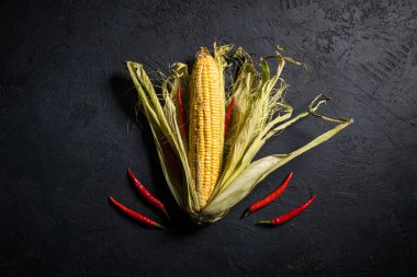 Siyah bir taş zemin üzerine biberli Mısır koçanı