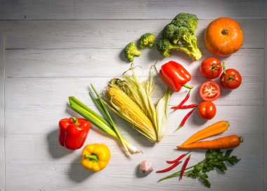 Beyaz ahşap zemin üzerinde sağlıklı taze sebze. Düz yatıyordu stili